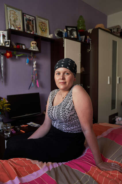 Die jugendliche krebskranke Michelle sitzt auf ihrem Bett. Der Fotoblog www station leben de ist ein Projekt von ROTE NASEN Deutschland 