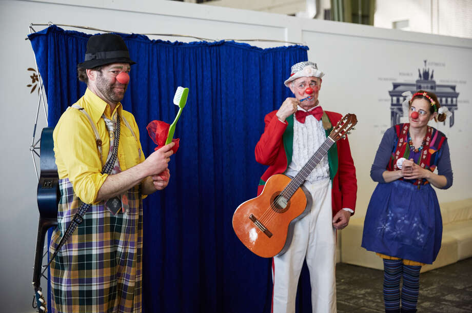 ROTE NASEN Zahnputzshow in Tempelhof drei Clowns stehen in einer Reihe, der eine hält eine große Zahnbürste in der Hand und der andere eine Gitarre