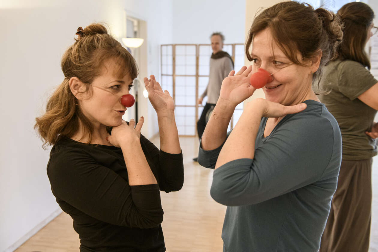 Zwei Künstler machen übungen mit roten Nasen auf 
