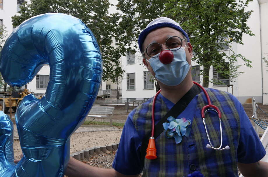 ROTE NASEN Clown Hubert von Hinten mit Mund-Nasen-Schutz hält Luftballons in der Hand. Anlass ist die Scheckübergabe der Spendenaktion "Die Region hilft helfen" am Potsdamer Klinikum Ernst von Bergman