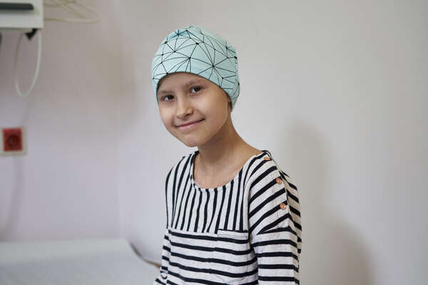 Die kleine Patientin Sienna sitzt in ihrem Krankenbett.