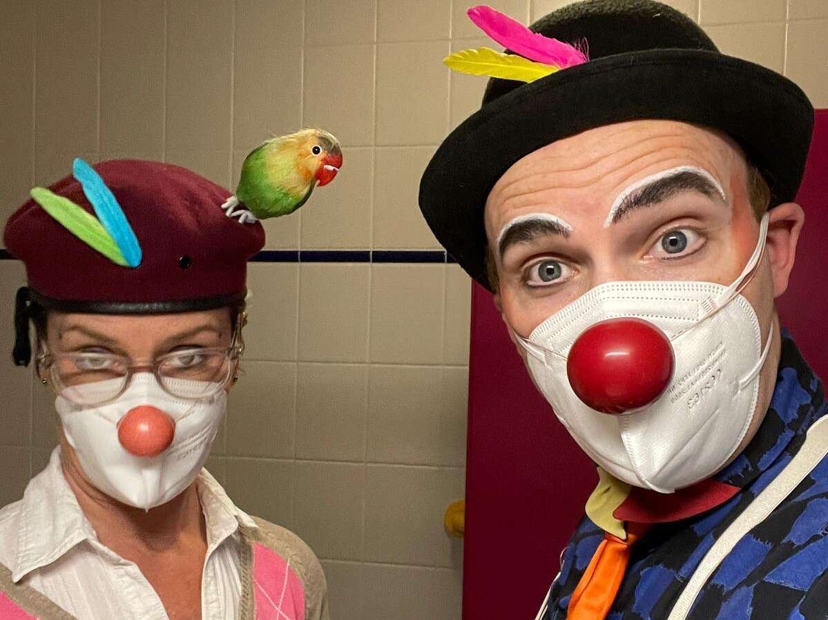 ROTE NASEN Clowns Bobby und Kleo schauen in die Kamera. Beide tragen bunte Federn am Hut. Sie besuchen Pflegebedürftige und Demenzkranke im Karl-Olga-Haus Friedrichshafen.