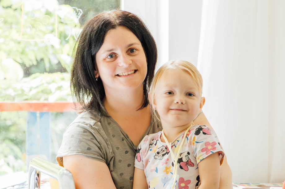 Eine Mutter hält ihre kleine Tochter in den Armen.