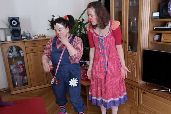 Zwei Clowns stehen in dem Wohnzimmer von einem Jungen der Geburtstag hat 