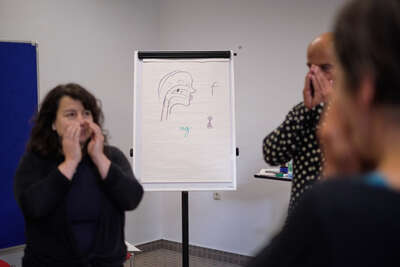 Drei Workshop Teilnemer umfassen mit ihren Händer ihre nase und ihren Mund 