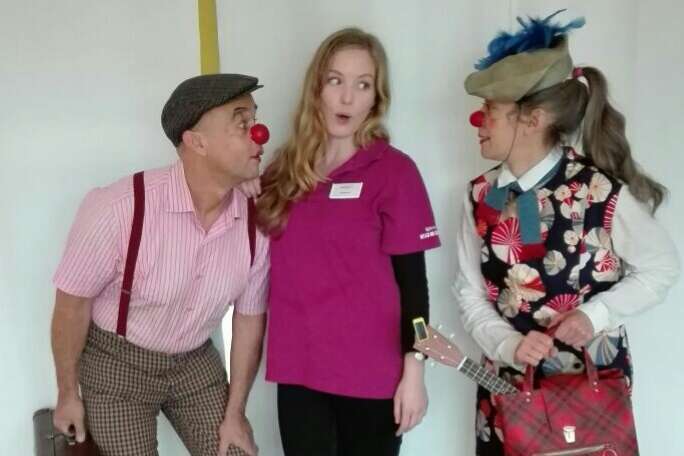 Zwei Klinikclowns stehen mit Heilerzieherpflegerin im Kinderhospiz
