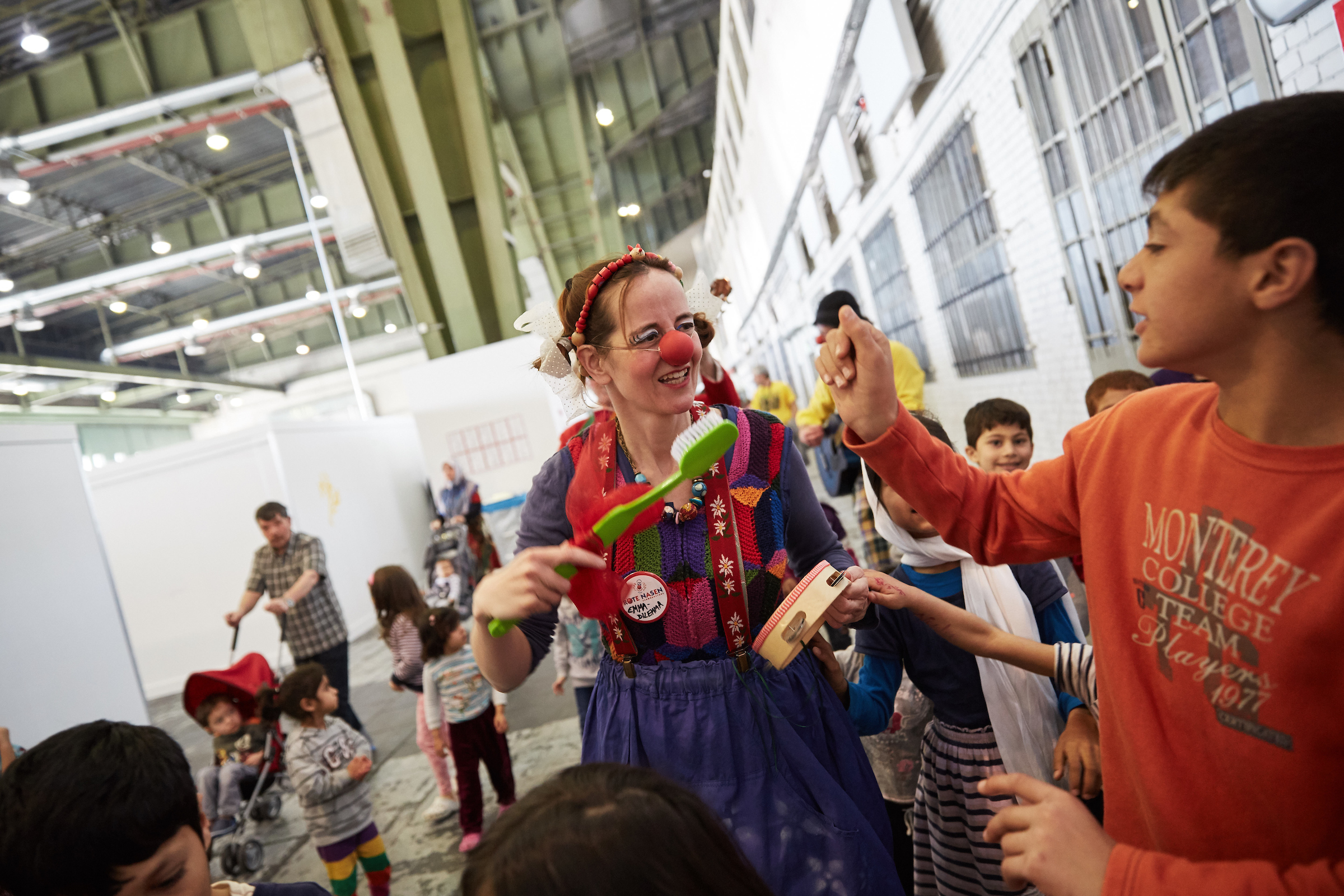 Clowns spielen in einer Flüchtlingsunterkunft vor ein paar jüngeren Kindern 