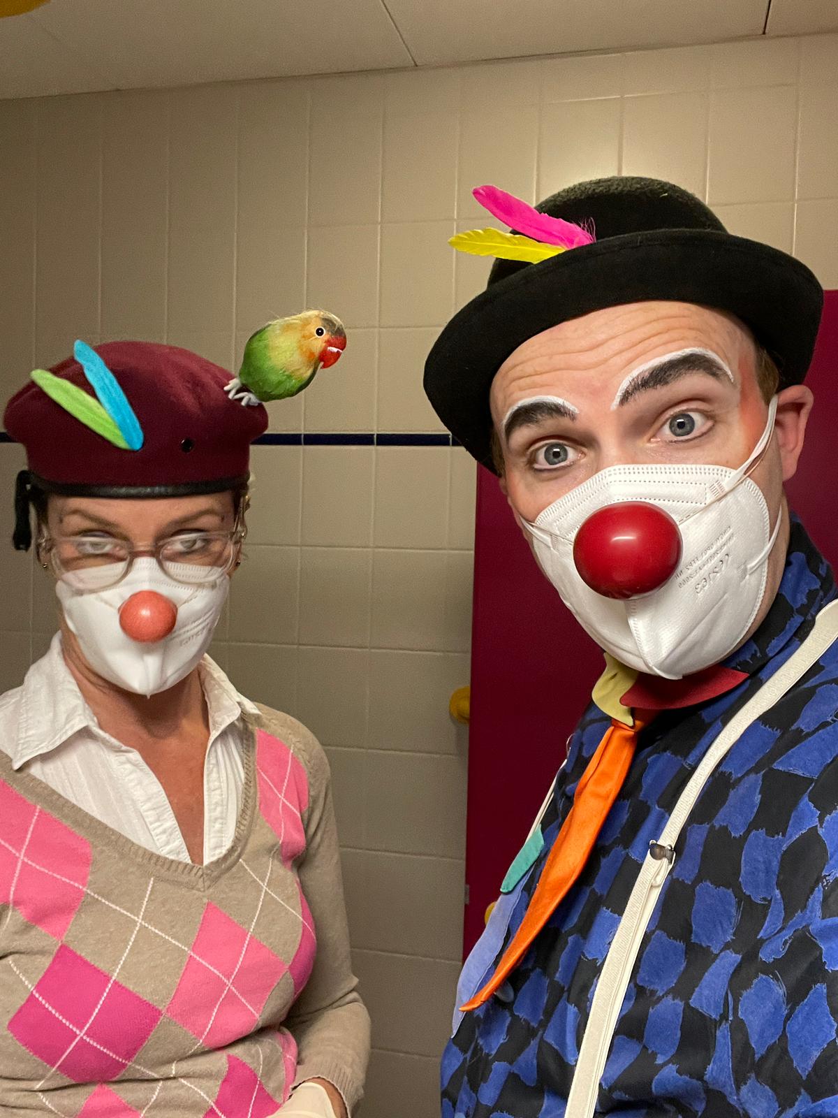 ROTE NASEN Clowns Bobby und Kleo schauen in die Kamera. Beide tragen bunte Federn am Hut. Sie besuchen Pflegebedürftige und Demenzkranke im Karl-Olga-Haus Friedrichshafen.