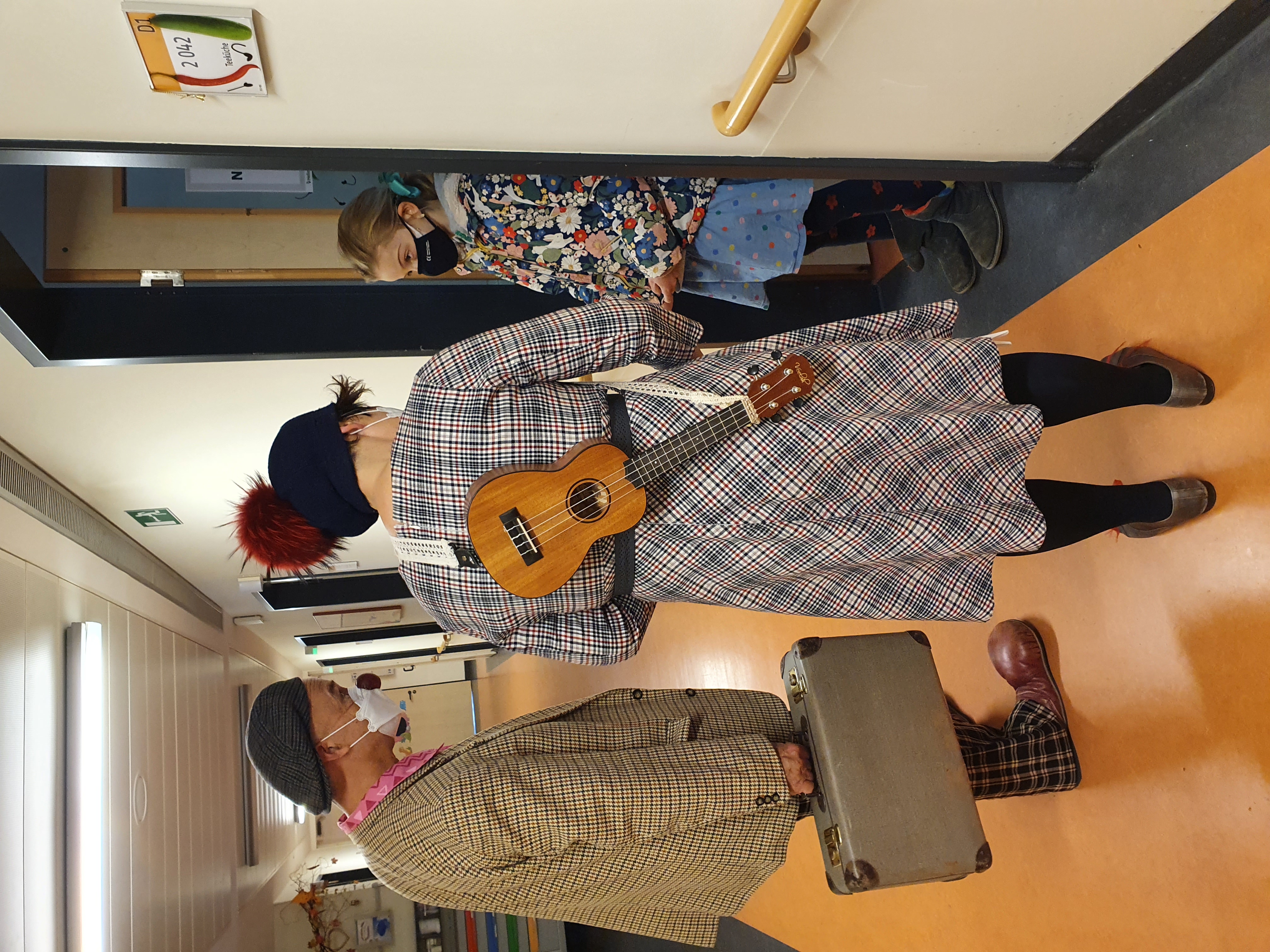 2 Clowns stehen im Krankenhaus vor der Tür der Patientin für den Besuch