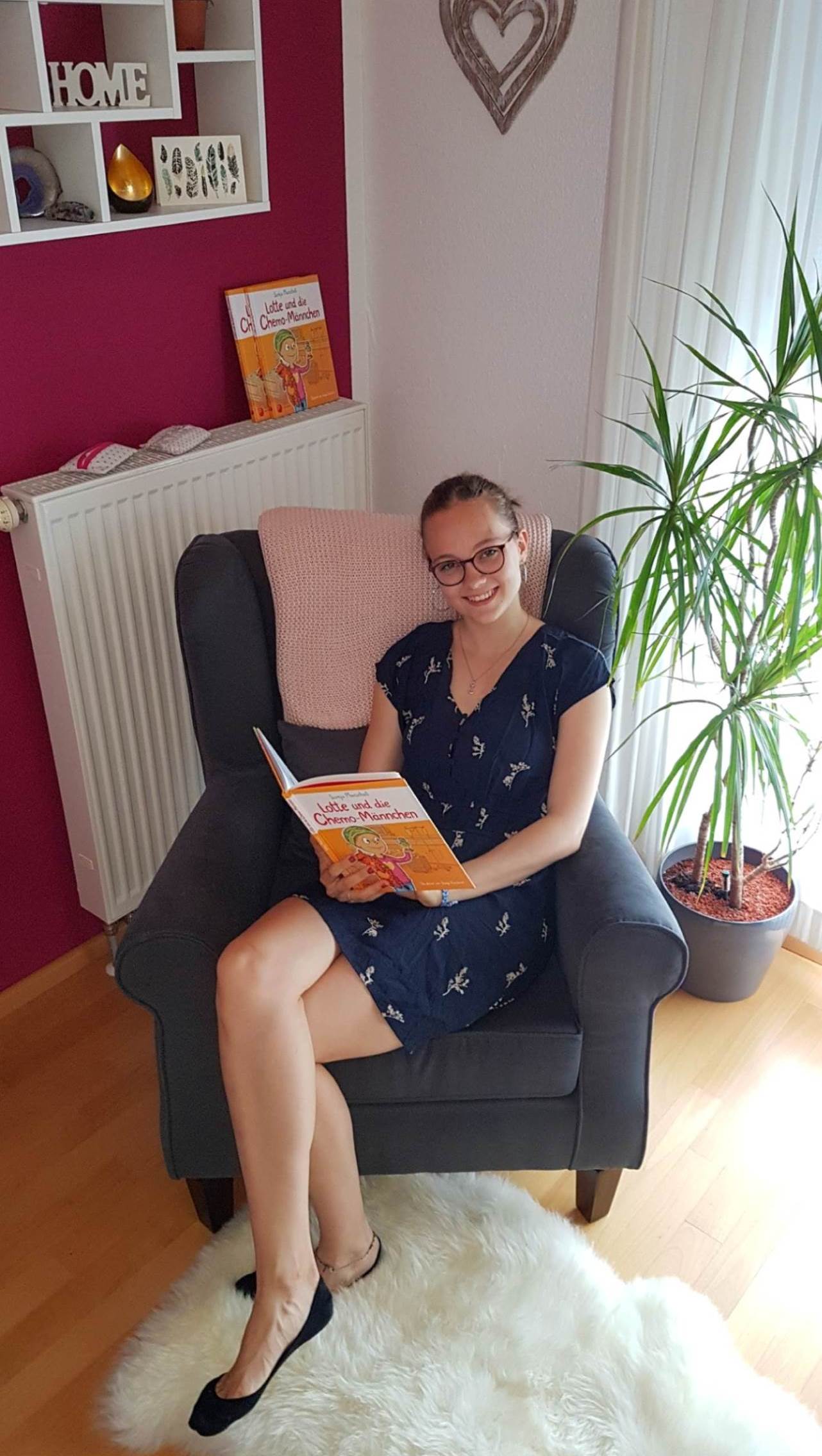 Ein Bild von Sonja Marschall wie sie in einem Seesel sietzt und liest 