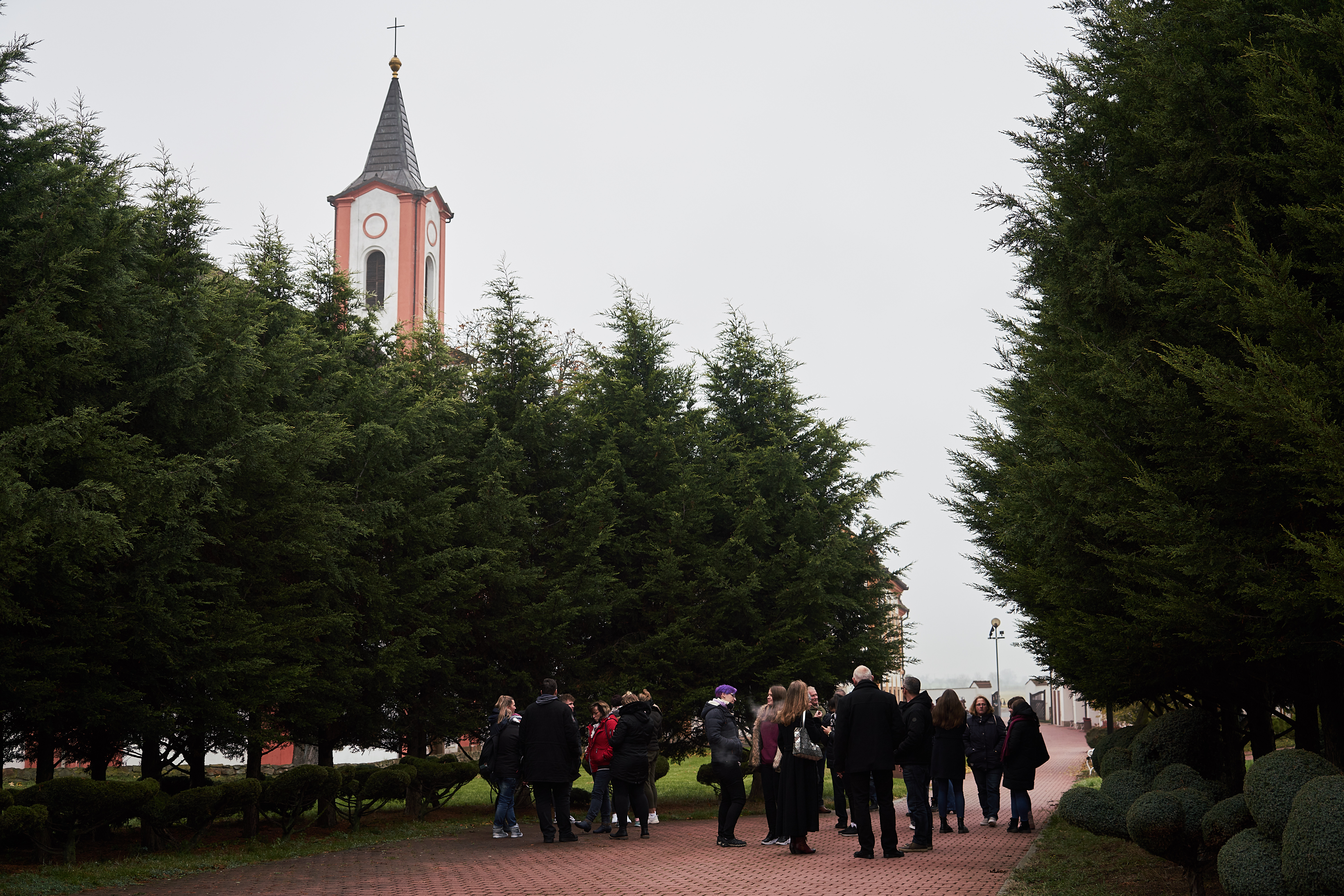 Eine Menschengruppe versammelt sich vor einer Kirche.