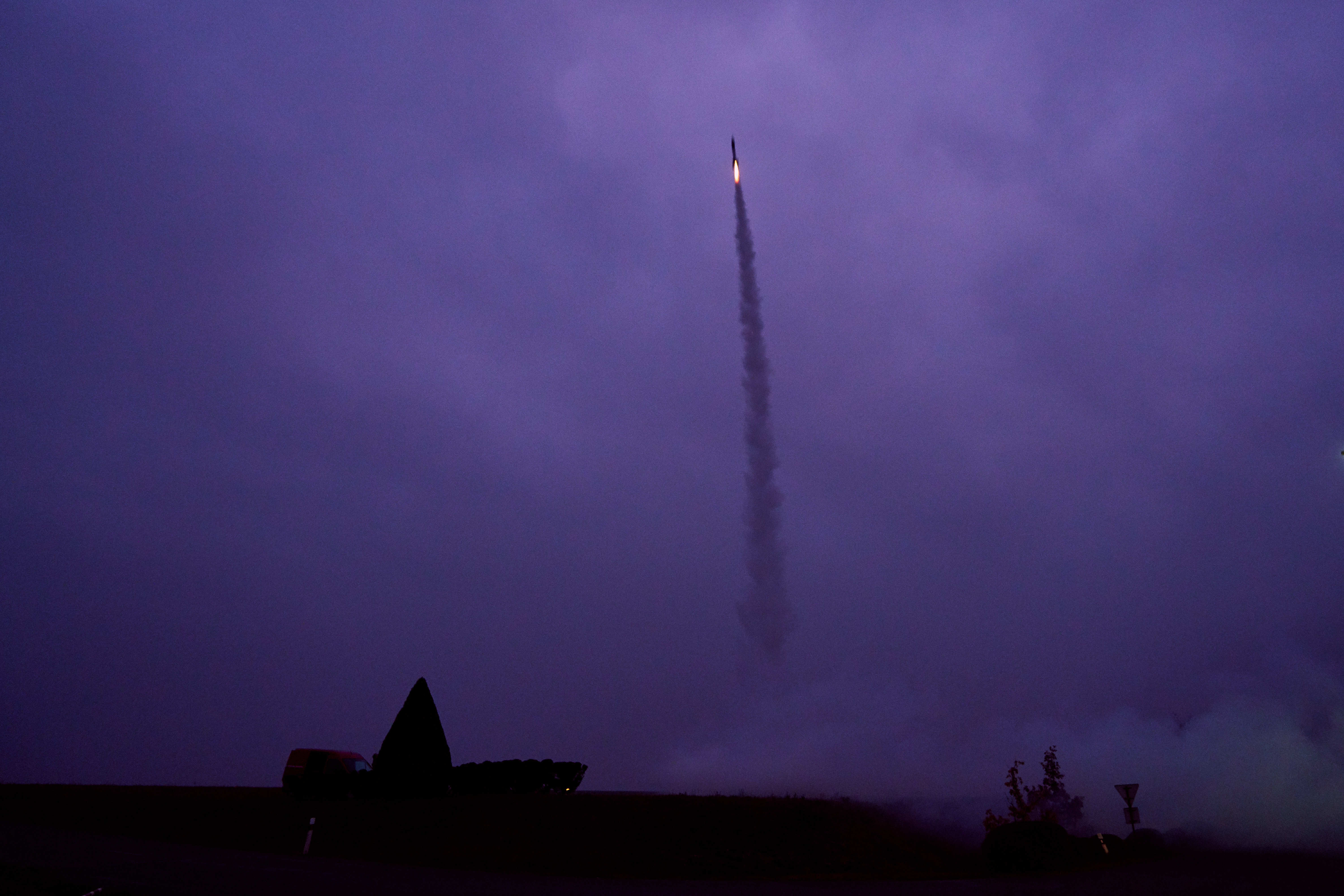 Eine Rakete fliegt in den Nachthimmel.