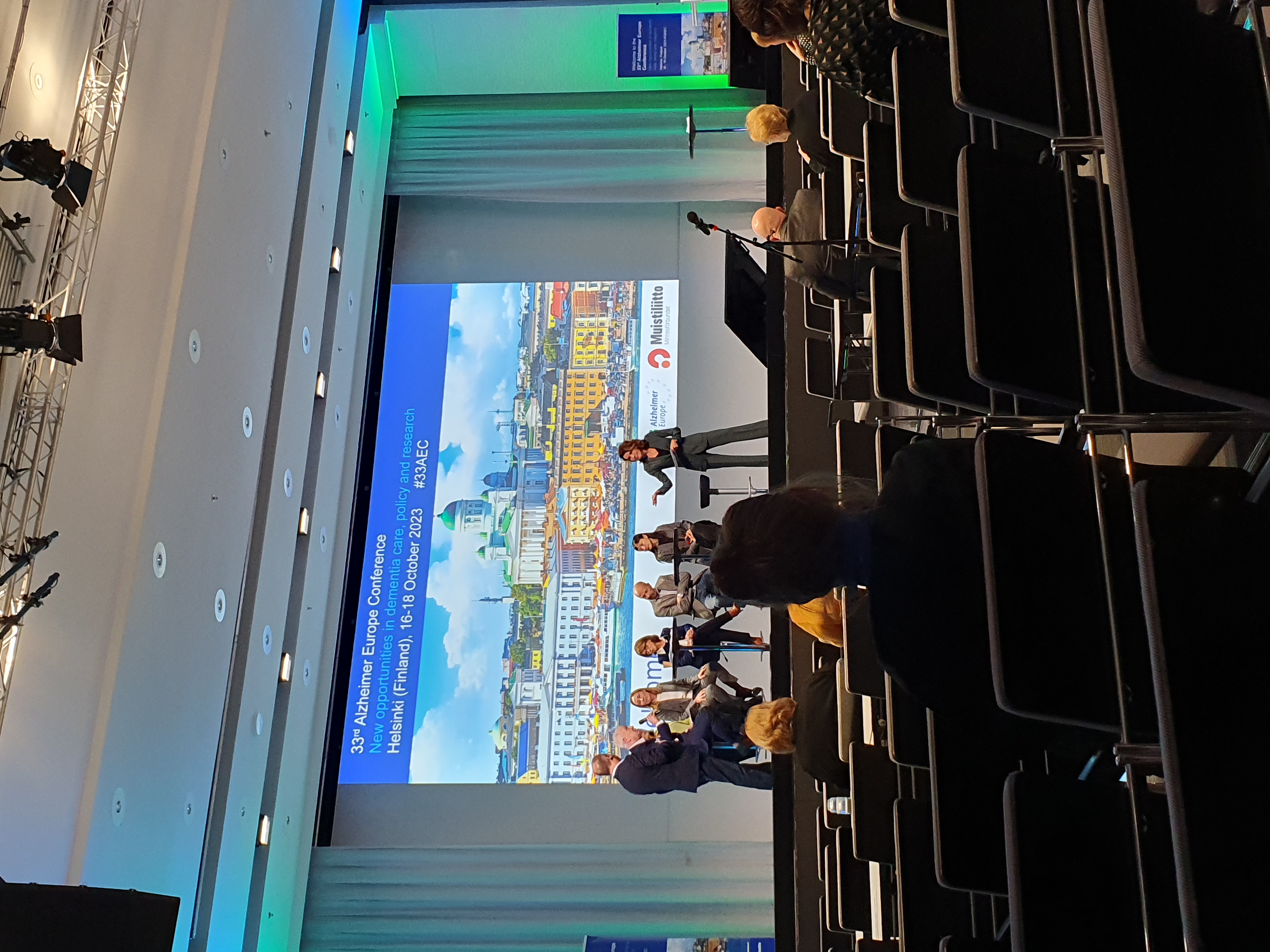 Konferenzsaal mit beleuchteter Leinwand.