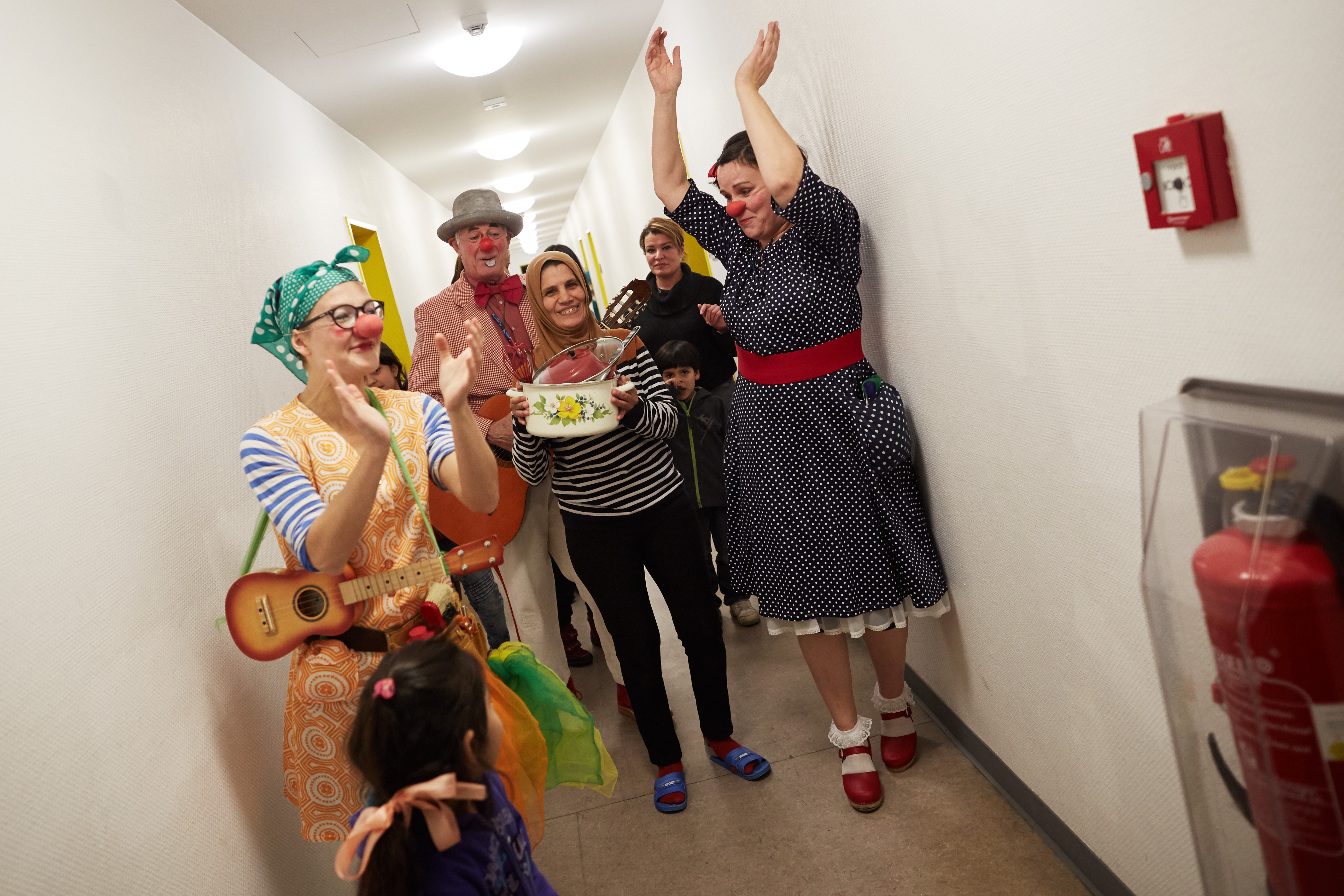 Kinder und Clowns machen Quatsch auf den Fluren des Fluchtlingheimes 