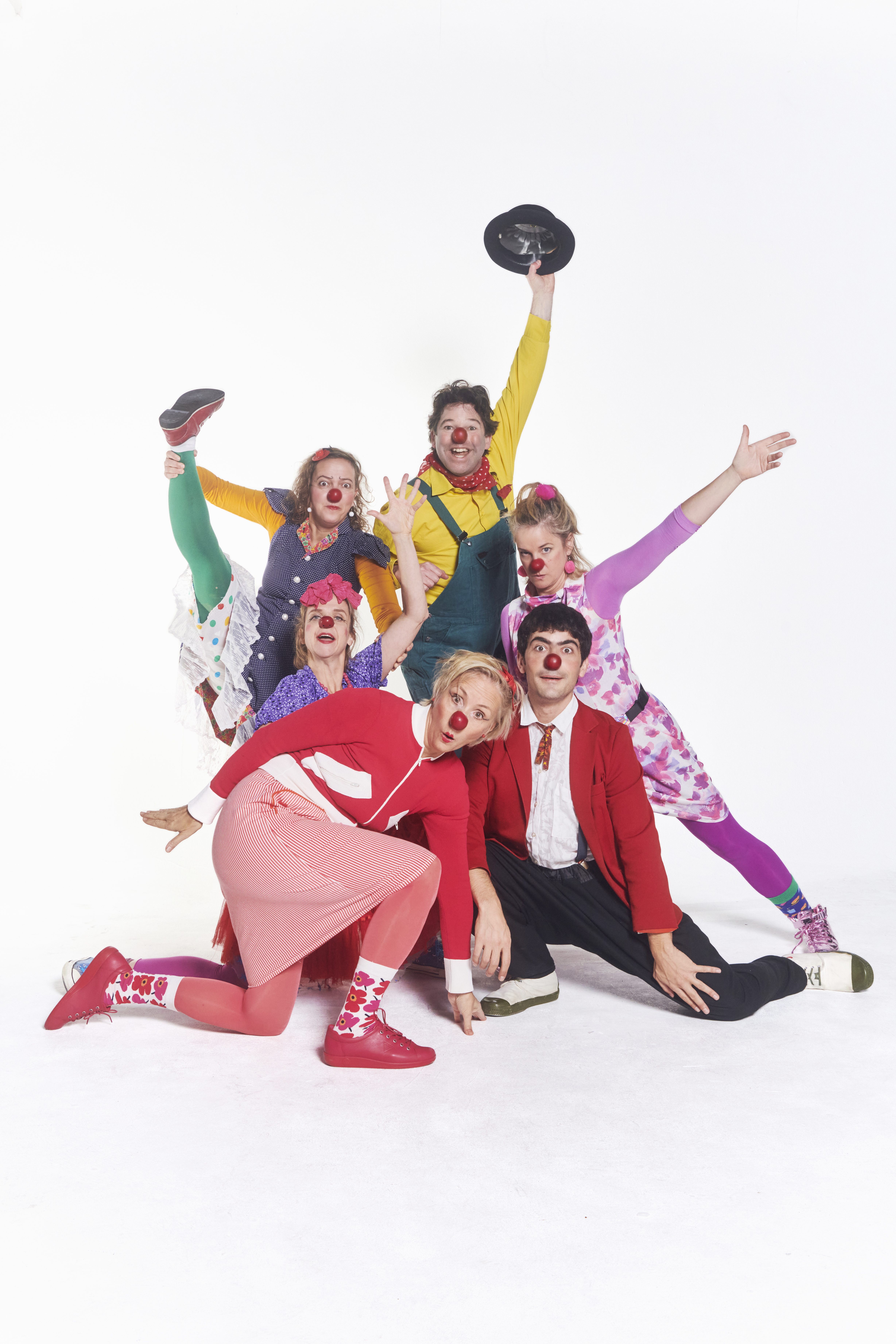 Sechs Clowns posen wild durcheinander. 