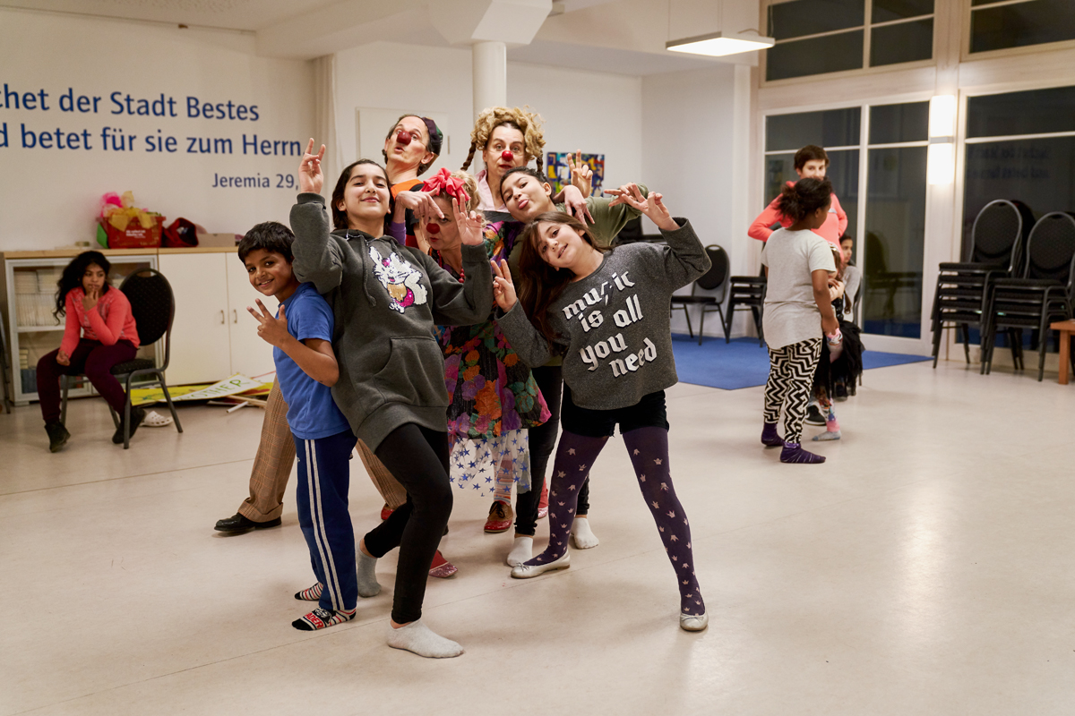 Die Clowns spielen mit den Kindern im Flüchtlingheim 