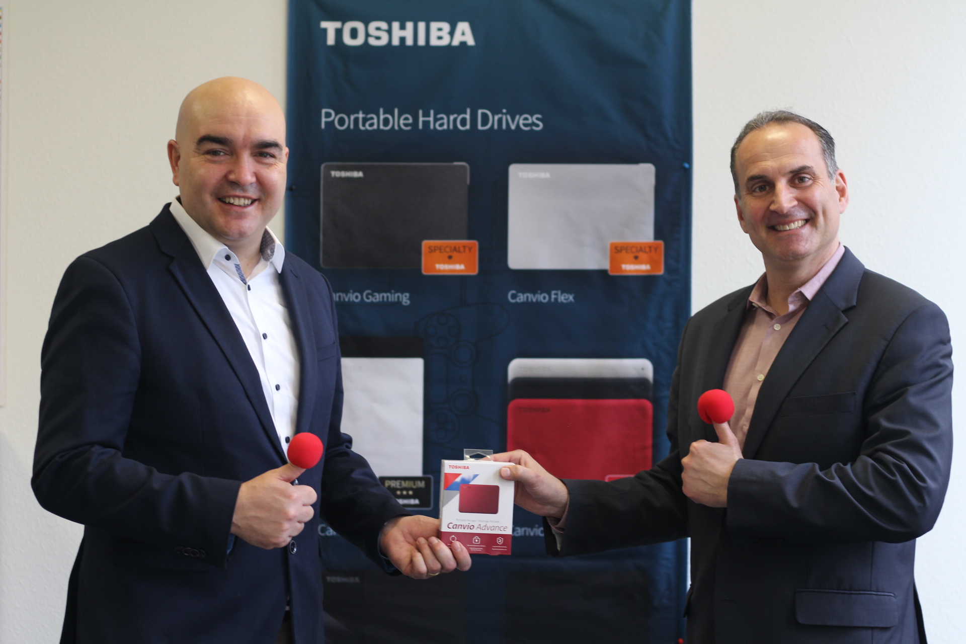 Mehran M. Goduarzi, Geschäftsführer des Klinikclownvereins ROTE NASEN Deutschland, bei der symbolischen Übergabe einer Festplatte durch Toshiba.